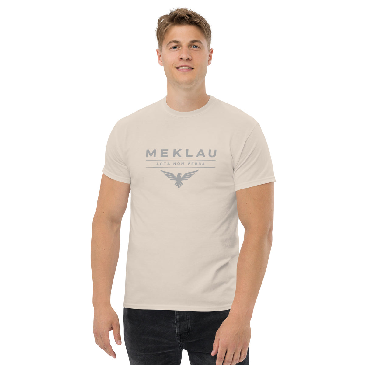 Man wearing a beige t-shirt with a small logo on a white background