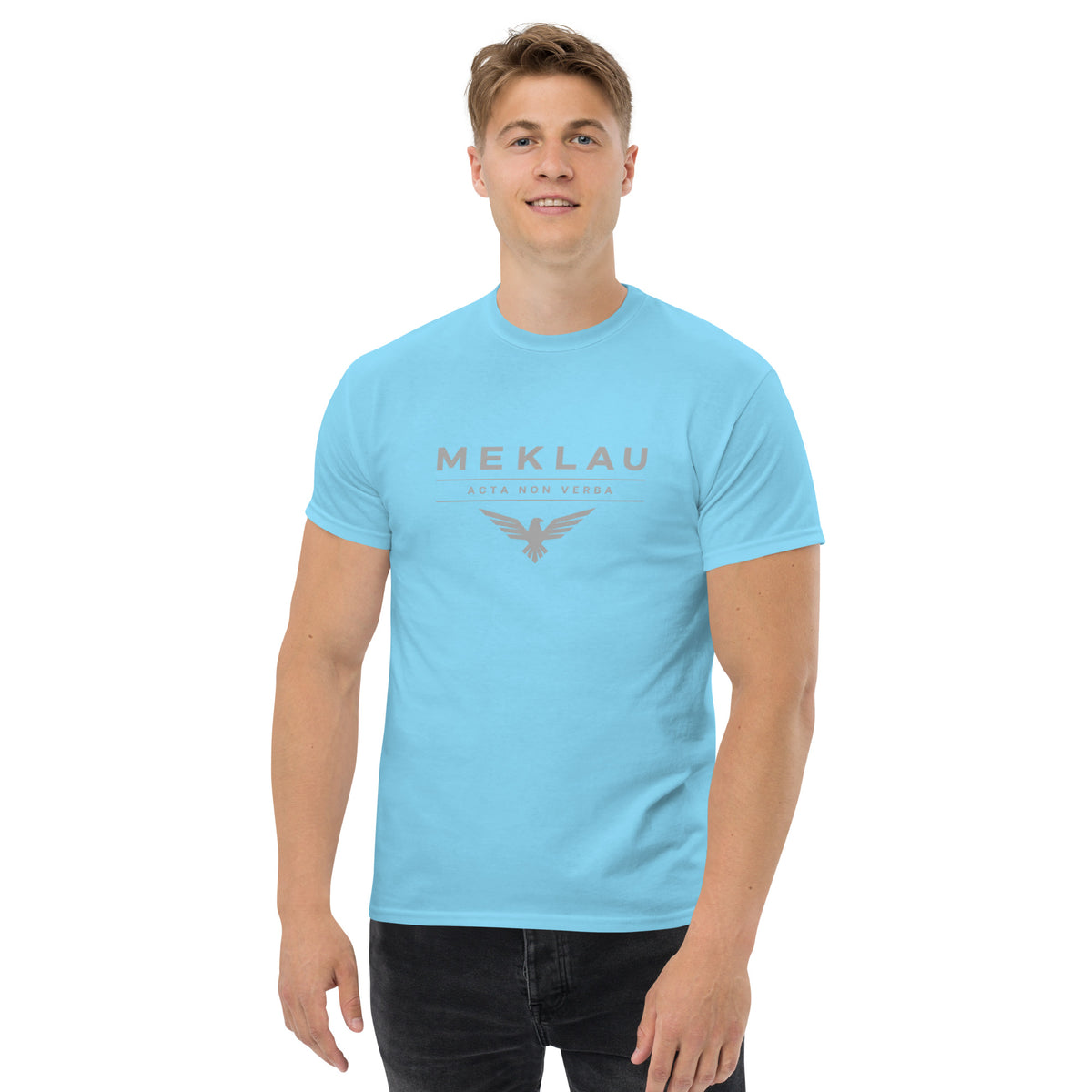 Man wearing a light blue t-shirt with a logo on a white background